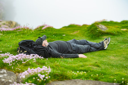 Tourist enjoying his time on the famous Cliffs of Moher, one of the most popular tourist...