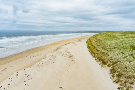 Spectacular Tullan Strand, one of Donegal's renowned surf beaches, framed by a scenic back drop provided by the Sligo-Leitrim Mountains. Wide flat sandy beach in County Donegal, Ireland.の写真素材