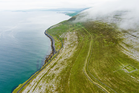 Spectacular misty aerial landscape in the Burren region of County Clare, Ireland. Exposed karst limestone bedrock at the Burren National Park. Rough Irish nature.の写真素材