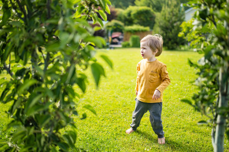 Adorable little boy having fun outdoors on sunny summer day. Kid running outdoors. Child exploring nature. Summer activities for small kids.の写真素材
