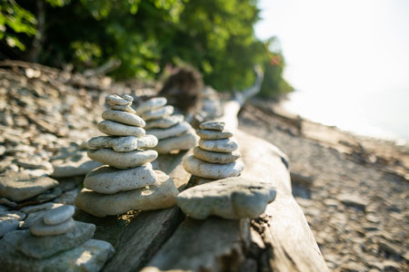 Balancing stones stacks on pebble beach near Valaste waterfall, reached by a wooden staircase, on...