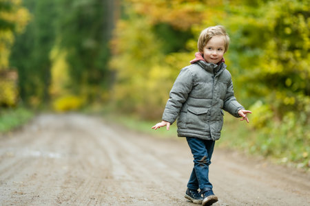 Cute little boy playing outdoors on sunny autumn day. Child exploring nature. Fall activities for...