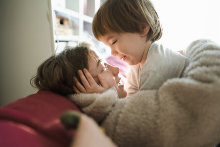 Cute big sister cuddling with her toddler brother. Adorable teenage girl holding baby boy. Children with large age gap. Big age difference between siblings.の写真素材