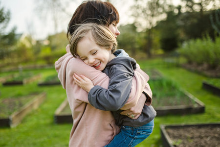 Cute big sister cuddling with her toddler brother. Adorable teenager girl hugging her small sibling. Children exploring nature. Siblings getting along.の写真素材