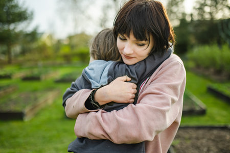 Cute big sister cuddling with her toddler brother. Adorable teenager girl hugging her small sibling. Children exploring nature. Siblings getting along.の写真素材