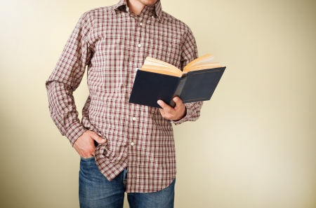 Man in brown plaid shirt reading a bookの写真素材