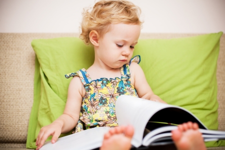 Baby girl reading a book の写真素材