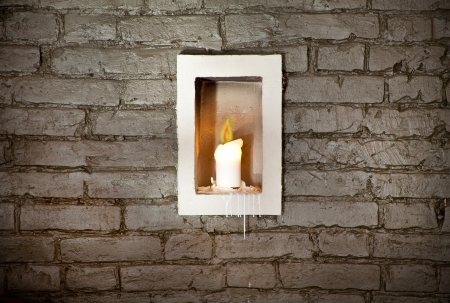 Old brick wall background, candle in the middleの写真素材