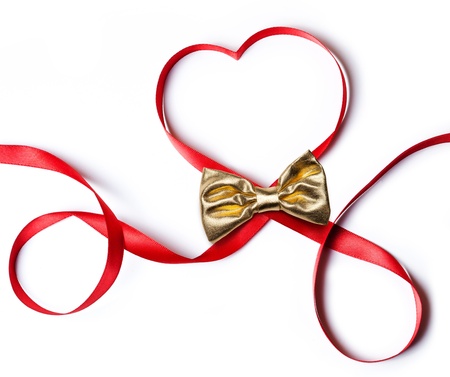 Red heart ribbon with golden bow, on white background の写真素材