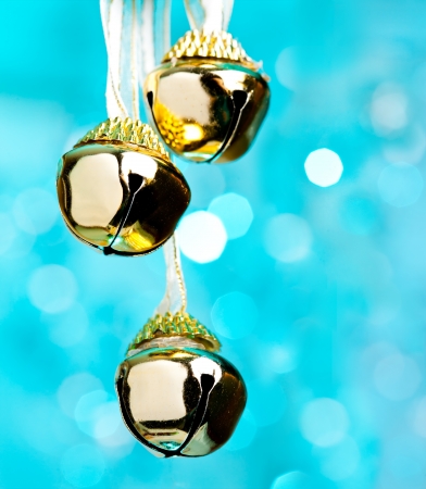 Christmas bells with ribbon, defocused blue lights on background の写真素材