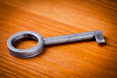Old key on wooden table, close up photoの写真素材