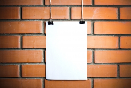 Blank white poster on a rope, brick wall on the backgroundの写真素材