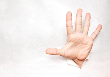 Hand through a hole in paperの写真素材
