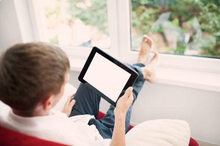 Man using tablet on sofa at homeの写真素材