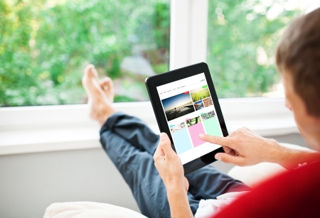 Man using tablet on sofa at homeの写真素材