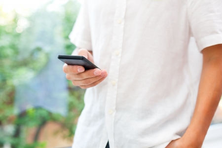 Close up of a man using mobile smart phone の写真素材