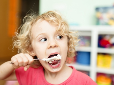 Cute little girl eating ice-creamの写真素材
