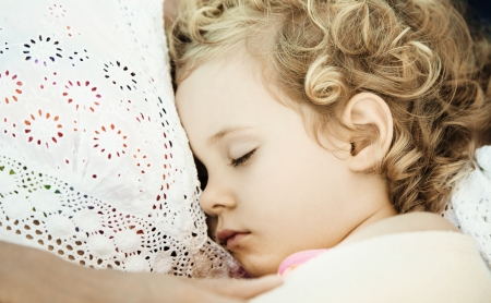 Mother and daughter sleeping on sofa at home, close up photoの写真素材