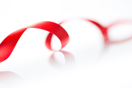 Beautiful fabric red ribbon on white background の写真素材
