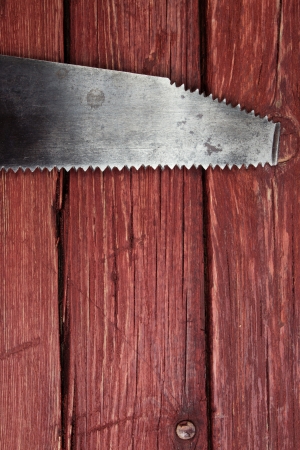 Old rusty saw on wooden background の写真素材