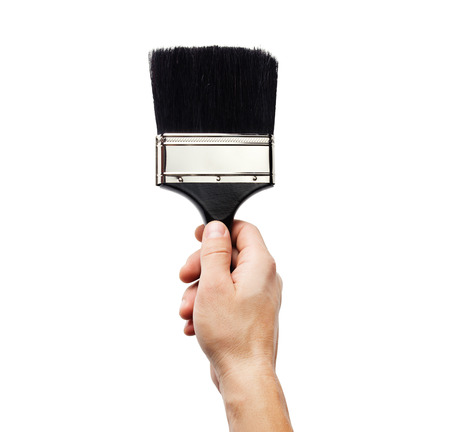 Hand holding big paintbrush isolated on whiteの写真素材