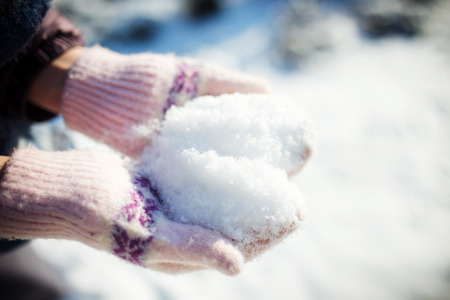 Heart shaped snow in women handsの写真素材
