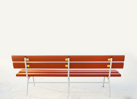 Wooden bench in snowy white landscape の写真素材