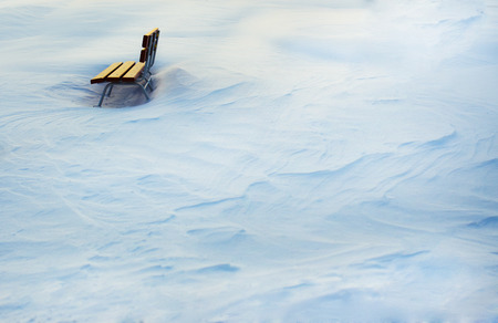 Wooden bench in snowy white landscape の写真素材
