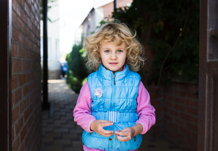 Portrait of cute blonde little girl playing outdoorsの写真素材
