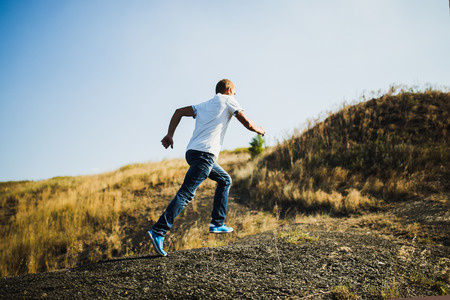 Young man in casual wear running uphill