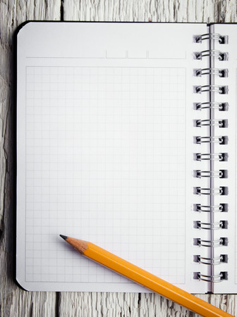 Open blank notepad with empty white pages laying on a wooden tableの写真素材