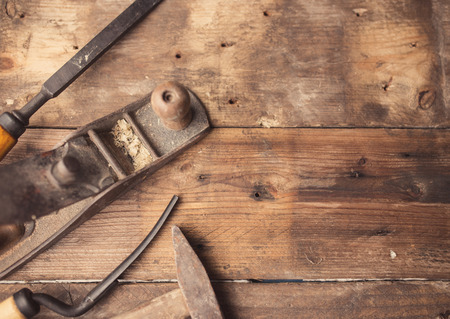 Od vintage hand tools on wooden background. Carpenter workplace.  Tinted photoの写真素材