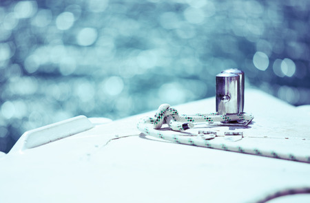 White mooring rope tied around steel anchor on boat or ship, tinted blueの写真素材