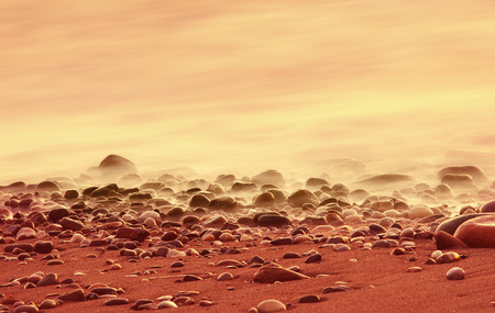 Pebbles on the beach and sea at sunset, long exposureの写真素材