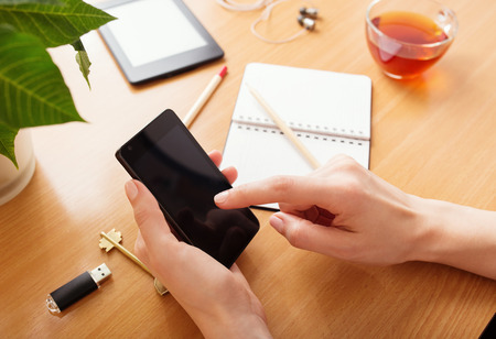 Close up of a woman using mobile smart phone at homeの写真素材