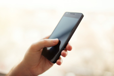 Close up of a man using mobile smart phone outdoorの写真素材