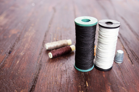 Thimble and needles for sewing close-up on a wood background. macroの写真素材