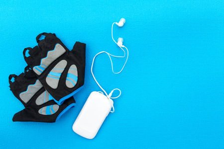 Cycling concept. Bicycle gloves and mp player on blue background.の写真素材