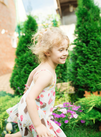 Little girl running on green grassの写真素材