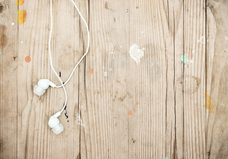 White modern portable audio earphones on woodの写真素材