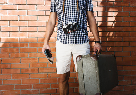 Urban manl, walking down the street, carrying suitcase and a map. Travel conceptの写真素材