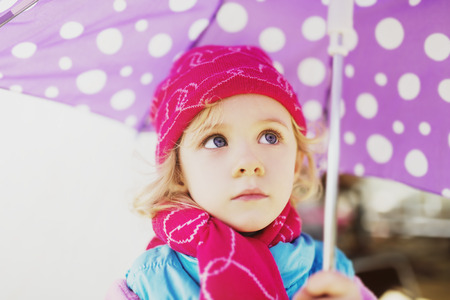 Little cute girl holding an umbrella, autumn outdoorの写真素材