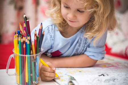 Portrait of child girl drawing with colorful pencilsの写真素材