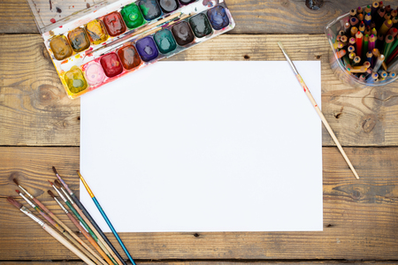 Plastic paint palette with paint and brushes on wooden tableの写真素材