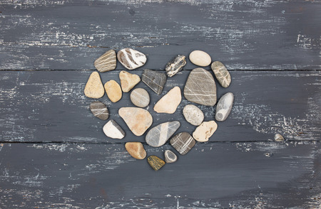 A heart shaped pebble stones on a old wood planksの写真素材