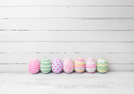 Easter eggs painted in pastel colors on white wooden background. Easter conceptの写真素材