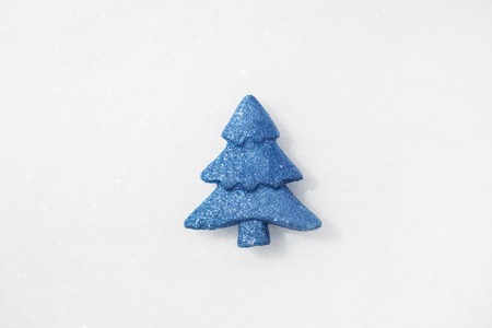 Minimalistic photo of blue toy tree on real snow at winter dayの写真素材