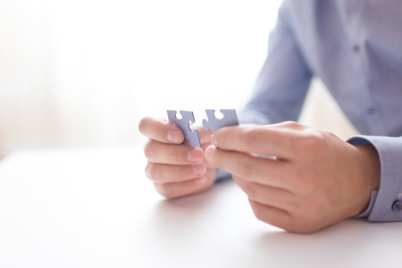 Businessman hands connecting jigsaw puzzle. Business solutions, success and strategy, learning concept. Close up photo with small dof.の写真素材