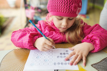 Little blonde girl making creative exercise at Easter.