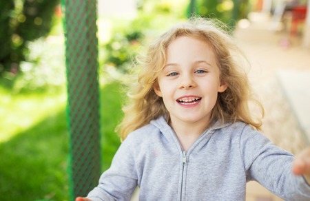 Outdoor portrait of cute smiling little blonde girl.の写真素材